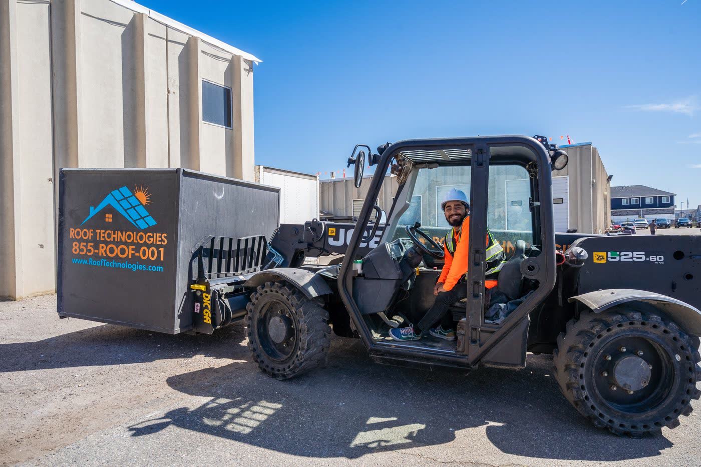 Roof Technologies branded JCB telehandler with operator on a major commercial dealership re-roof project