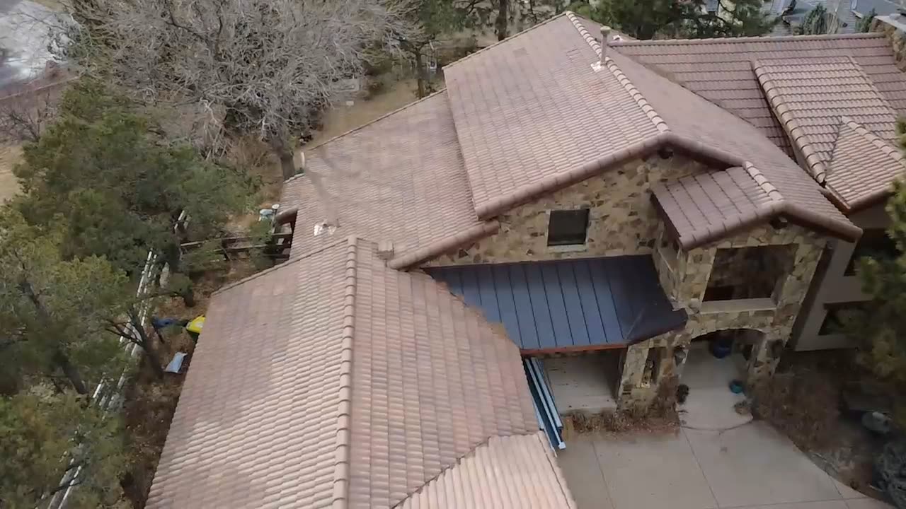 Standing-seam metal accent over a tile-roof entry porch, custom Front Range home